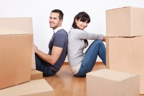 Trained removals staff handling furniture safely with gloves and safety footwear