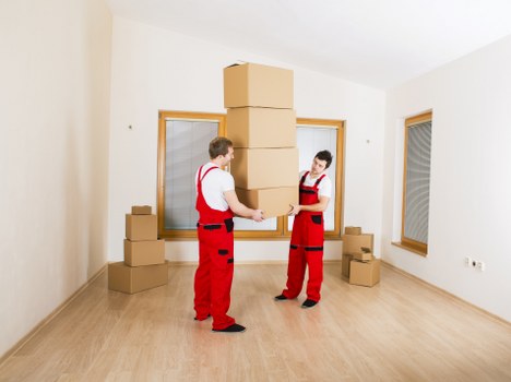 Professional movers handling furniture and boxes during an Acton removal